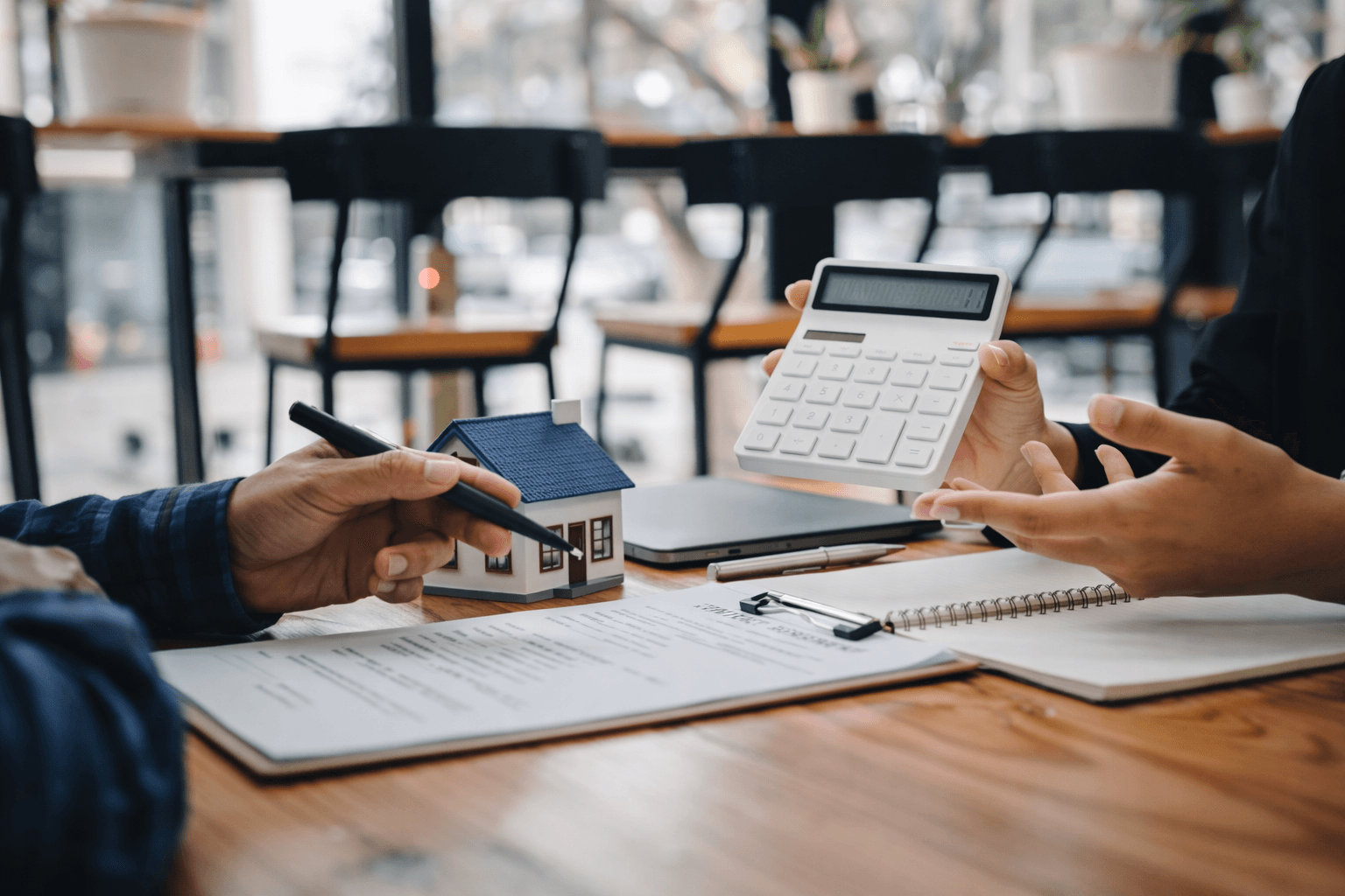 Property investment consultation with model house and calculator